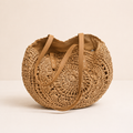 Lola | Bolso redondo de paja trenzada con motivo — cognac